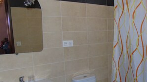 Kylpyhuoneessa on valkoinen pesuallas, wc ja peili, joka on sijoitettu pesualtaan yläpuolelle.