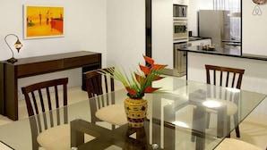 A modern dining area with a glass table, wooden chairs, and a decorative vase. - Ipanema (Rio de Janeiro)