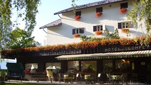 A hotel with a restaurant on the ground floor, outdoor seating, and flower boxes on the facade. - Hotel Compet (Vignola-Falesina)
