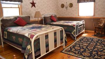 Una habitación con dos camas individuales, suelo de madera, decoración de estrellas y una ventana con cortinas.