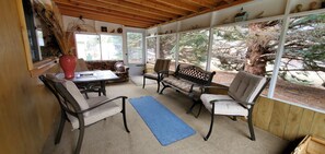 A covered patio with a table, chairs, and a blue rug. - On Salmon River, quiet, private, house, where you can still see the milky way, (Salmon)
