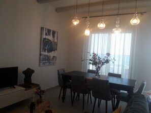 Enjoy meals together at the dining table with six chairs, surrounded by a flat-screen TV and a beautiful painting.