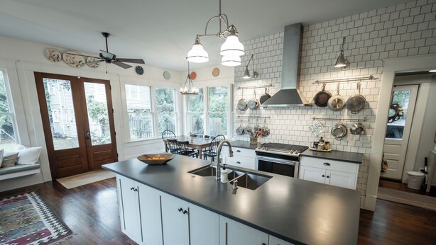 A modern kitchen with a central island, white cabinetry, and a brick backsplash. - 5 Points Bungalow, Athens, GA (Athens)