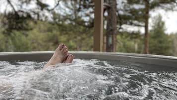 A person relaxing in a hot tub with water splashing around.