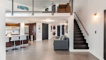 A spacious living area with a kitchen, a staircase, and a dining area.