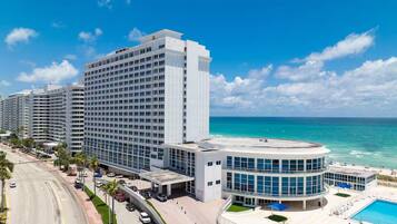 Un hôtel de grande hauteur doté d'une piscine et offrant une vue sur la plage.