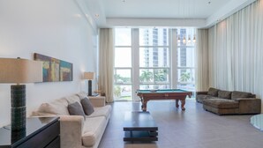 A spacious living room with a pool table, a sofa, and a coffee table. - BIGGEST BEACHFRONT 3 bedroom apartment with parking on the BEACH (Miami)