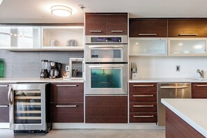 Une cuisine moderne dotée d’appareils électroménagers intégrés, notamment un réfrigérateur, un four et un four à micro-ondes.