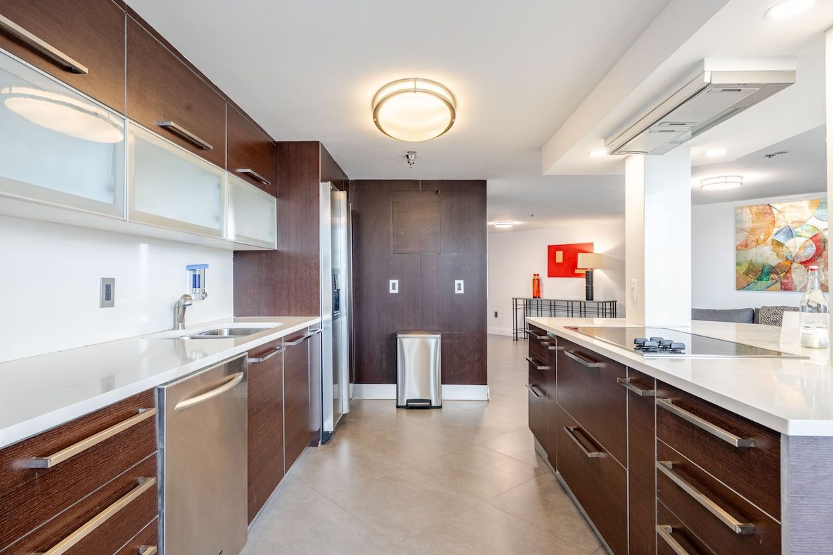 A modern kitchen with a central island, stainless steel appliances, and a minimalist design.