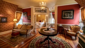 A room with a chandelier, a round table, a sofa, and a chair. - All inclusive Bed and Breakfast (McCloud)