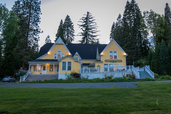 A yellow building with a porch and a staircase leading to a deck. - All inclusive Bed and Breakfast (McCloud)