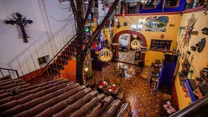 A multi-level interior with a staircase, dining area, and various decorations.