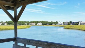 A wooden deck overlooking a calm lake with houses in the background.