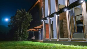 Una casa moderna con amplios ventanales y fachada de madera.