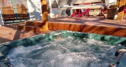 lomakeskuksen kaltainen 4 makuuhuoneen talo, jossa on kylpytynnyri ja 2 ulkokäyttöön tarkoitettua tulisijaa