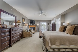 A bedroom with a large bed, a dresser, a television, and a fireplace. - 5 BR BEAUTY-WALK/BIKE TO REHOBOTH BEACH & BOARDS-Pool Cmmty- 19853 Church St. (Rehoboth Beach)