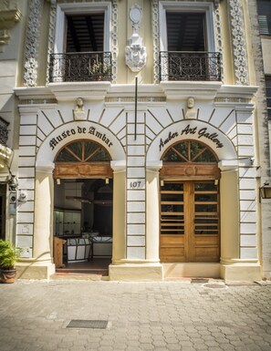 A building with two arched entrances labeled "Museo de Amber" and "Amber Art Gallery." - 2 Bedroom Apartment (Santo Domingo)