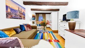 Un soggiorno accogliente con un divano, un tappeto colorato e un vaso decorativo.