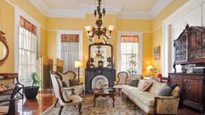A traditional living room with a fireplace, comfortable seating, and classic decor. - Ashton's Bed and Breakfast (New Orleans)