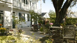 A white house with a balcony, outdoor furniture, and a large tree. - Ashton's Bed and Breakfast (New Orleans)