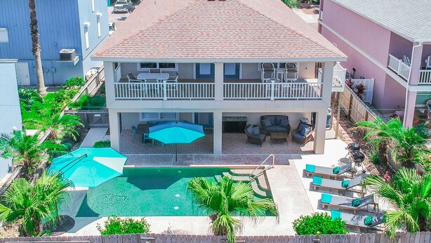 A two-story house with a balcony, a swimming pool, and a fenced backyard. - Southern Destination: Bask longer, save 10% on stays of 7+ nights! (South Padre Island)