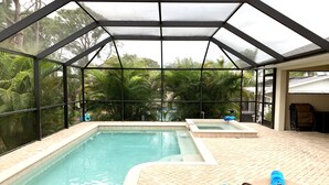 A covered outdoor pool area with two hot tubs, lounge chairs, and a patio with a brick floor. - * Where beach days, pool nights, and unforgettable memories begin! * (Englewood)