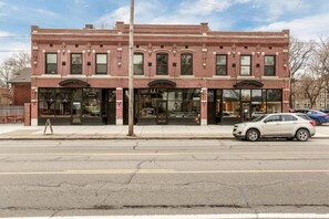 A two-story brick building with large windows and a storefront.