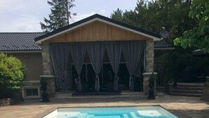 A rectangular swimming pool with clear blue water, surrounded by a stone deck.