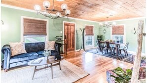 Un salon comprenant un canapé, une table basse et un coin repas avec des chaises et une table.
