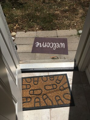 Un felpudo y una alfombra de entrada en la puerta de un edificio.