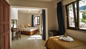 Een hotelkamer met een bed, een bureau en een raam met gordijnen.