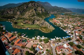 An aerial view of a coastal town with a river, boats, and residential buildings. - Turay Hotel (Ortaca)
