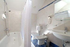 A bathroom with a bathtub, toilet, bidet, and sink. - Guesthouse Bajc (Vrhnika)