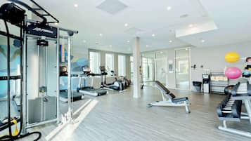 A modern gym with cardio machines, weightlifting equipment, and exercise balls.