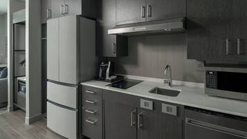 A modern kitchen with a built-in microwave, a coffee maker, and a refrigerator.