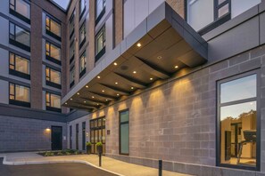 Un edificio moderno con una galería techada, ventanas amplias y fachada de ladrillo.