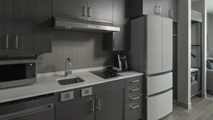 Une cuisine moderne avec des meubles en bois foncé, des appareils électroménagers en acier inoxydable et un lave-vaisselle intégré.