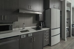 Una cocina moderna con armarios de madera oscura, electrodomésticos de acero inoxidable y lavavajillas integrado.