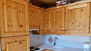 Une cuisine avec des meubles de rangement en bois, une cuisinière, un évier et un lave-vaisselle.