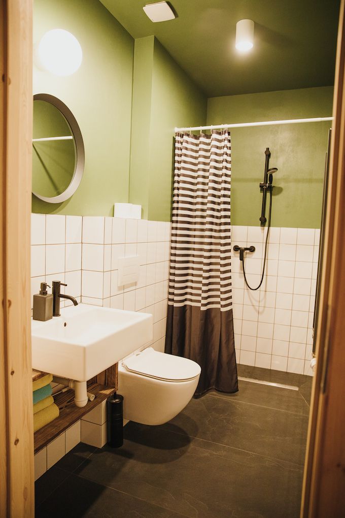 Un baño con lavamanos, inodoro y ducha blancos.