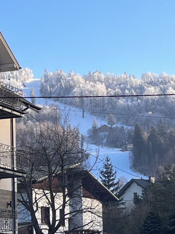 A residential area with houses, a balcony, and a snowy mountain backdrop.