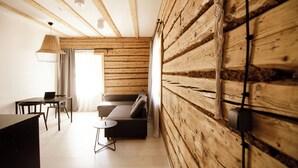 Een moderne kamer met houten wanden, een bank, een eettafel en een laptop.