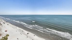 Une plage avec un rivage sablonneux et des vagues de l’océan.