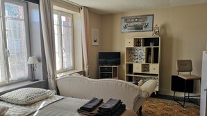 Une chambre d’hôtel avec un lit, une télévision, une bibliothèque et un bureau.