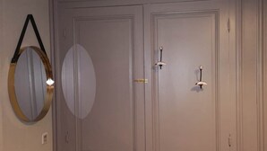 Une porte double fermée, avec un miroir rond accroché au mur.