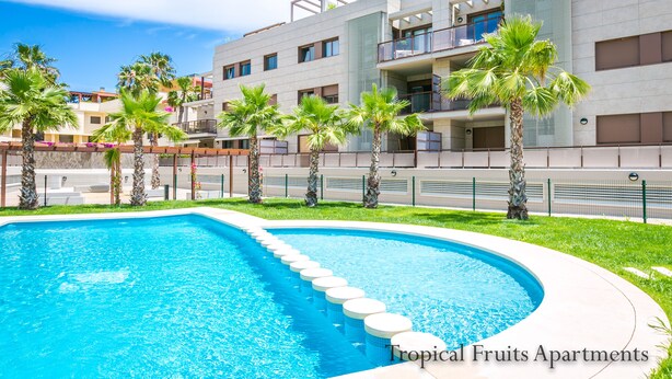 A modern apartment complex with a swimming pool, palm trees, and balconies. - Apartment Lychee - Golden Star Javea close to Arenal beach. (Xàbia)
