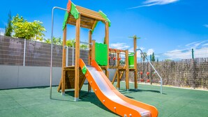 A playground with a slide and climbing structures. - Apartment Lychee - Golden Star Javea close to Arenal beach. (Xàbia)