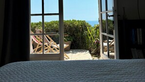 Une chambre avec une grande fenêtre, un lit et une vue sur la mer.