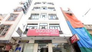 Un edificio de varios pisos con un letrero rojo llamativo para INDO.