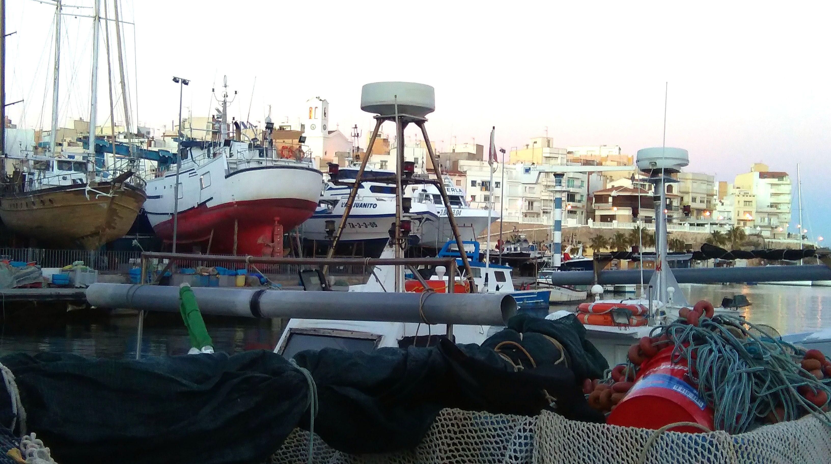 A marina with several boats docked, including a large red and white ship.